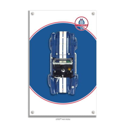 Shelby Cobra 427 S/C LEGO 10357 – Style Pastille Bleue Logo Cobra Réaliste, finition Entretoises – Fond blanc avec pastille bleue et logo Cobra réaliste, vis aux 4 coins – Tableau mural aluminium Kadris